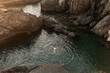 © Lupe Rodriguez/Stocksy - Man bathing in the sea at the port of Manarola in Cinque Terre, Italy