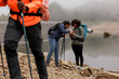 © BONNINSTUDIO/Stocksy - Hikers checking location on mobile phone by lake