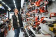 © Serhii - A man chooses a power tool in a hardware store