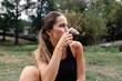 © Adrian Rodd/Stocksy - Fitness woman sipping a cup of coffee in the middle of a meadow