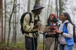 © BONNINSTUDIO/Stocksy - Group of friends hiking and navigating in forest using map