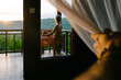 © Alexander Grabchilev/Stocksy - A person enjoys a peaceful morning sitting on a wooden balcony