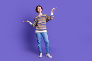 Wall Mural - Photo of lovely cute cheerful woman wear trendy clothes hold empty space isolated on purple color background