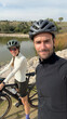 © Adrian Rodd/Stocksy - Couple of gravel cyclists take a selfie during a training afternoon