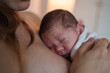 © Artem Zhushman/Stocksy - Baby sleeps peacefully in mother's arms