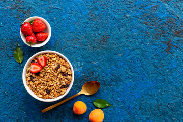 Wall Mural - Bowl with oatmeal granola and ingredients - apricots and strawberry. Top view