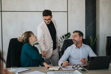 A multicultural group of business people engaging in a productive meeting, showcasing teamwork and collaboration in a modern office environment. The image captures a positive and professional