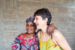 © Alvaro Lavin/Stocksy - Senegalese woman and european volunteer laughing together in africa