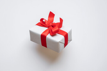 Wall Mural - simple white paper craft gift box with red ribbon bow in dynamic angle.anniversary and special day w