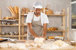 © JackF - Adult man baker kneading dough for baking on table