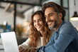 © btiger - Happy male and female managers working together on laptop in office discussing corporate technology