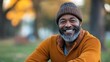 © Mr. Muzammil - Happy Mature Man Smiling Outdoors in Autumn Park Setting