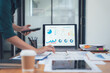 © Kritdanai - Analyzing Data: Businesswoman reviewing financial reports and charts on laptop.