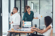 © Nittaya - Business Meeting Tension: A tense moment in the office, with a passionate female leader presenting data while her colleagues react with concern and intensity.