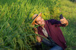 © kamonrat - Farmer Taking a Selfie in a Rice Field, Documenting Crop Health and Celebrating Harvest Season with Modern Technology, Embracing Rural Life and Sustainable Agriculture Practices