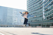 © Cavan Images - Young latin woman jumping with joy in a modern city setting