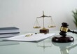 © Alexandra - Gavel, scale, legal books and documents on glass table symbolize the legal system and justice