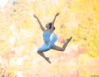 © Connect Images - Ballerina mid-leap against a backdrop of autumn leaves, exuding grace and athleticism.