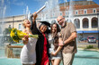 © Connect Images - Graduation celebration with a happy graduate holding a diploma and flowers, posing with friends and family by a fountain on a sunny day, Bournemouth, Dorset UK