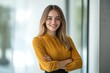 © Alexei - A woman in a yellow shirt stands with arms crossed, smiling