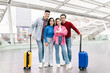 © Prostock-studio - A happy couple stands with two friends in an airport terminal, ready for their weekend getaway. Bright smiles and colorful luggage show their excitement for travel and adventure.