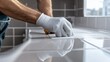 © Suphawan - Worker sealing a kitchen backsplash edge with waterproof silicone caulk