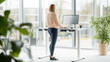 © sabyna75 - Modern office efficiency: model using a standing desk in a bright co-working space