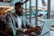 © wiparat - Businessman Uses Laptop, Waiting for a Flight. Traveling Entrepreneur Working Online