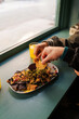 © Alberto - Two friends are enjoying a plate of nachos with guacamole, accompanied by glasses of orange juice