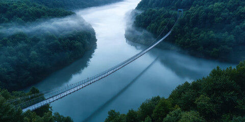 Wall Mural - serene foggy river valley with suspension bridge surrounded by lush green forest