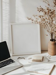 Canvas Print - A blank white frame in a small home office nook, viewed from a slightly elevated angle, surrounded by a laptop and scattered notes