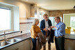 © Marko Geber - Elderly couple consulting with real estate agent in new home kitchen