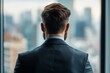 © c80 - A man dressed in a formal suit stands with his back turned, gazing over a sprawling urban cityscape from a high vantage point, signifying contemplation and ambition.