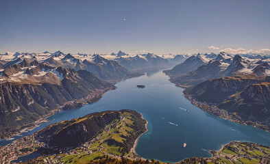 Fototapete - Mountain range with a lake in the middle. The lake is surrounded by mountains and has a small island in the middle