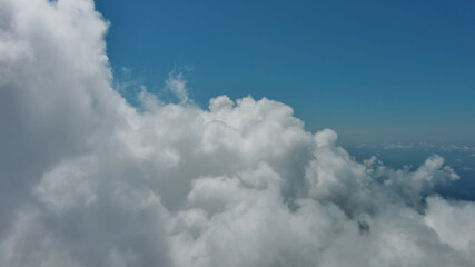 Wall Mural - Flying through white fluffy clouds
