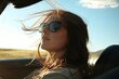 © vasyan_23 - Young caucasian female enjoying a drive on a sunny day with sunglasses and windblown hair