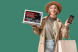 © Pixel-Shot - Young woman in autumn clothes with laptop and mobile phone shopping online on green background