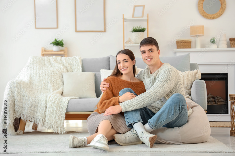 Loving young happy couple sitting on floor at home