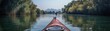 © Iswanto - A serene kayaking scene on a calm river surrounded by lush greenery and mountains.