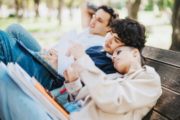 Poster - A group of relaxed students studying together on a park bench, enjoying a sunny day outdoors, discussing notes and bonding through shared learning moments.