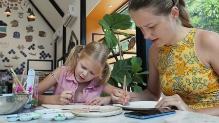 Wall Mural -  A young mother and her daughter enjoy a creative art session at home 