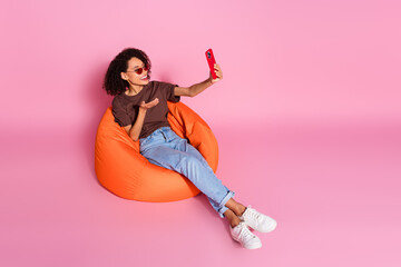 Poster - Photo of cute pretty cheerful girl blogger sitting speaking video call isolated on pink color background