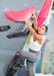 © JackF - Young sporty woman training at bouldering gym without special climbing equipment