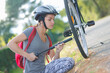 © auremar - young woman pumping up tire tyre with bike bicycle pump