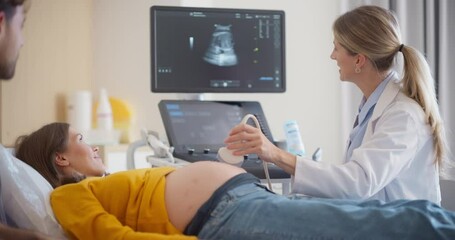 Aufkleber - Modern Prenatal Ultrasound Session in a Hospital. Female Doctor Examining a Fetus on Computer Monitor. Pregnant Woman Smiles as Her Boyfriend Offers Comfort Beside Her in the Medical Office