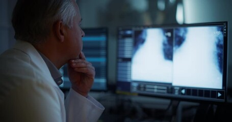 Aufkleber - Middle Aged Doctor Inspecting Chest X-rays on a Computer Screen in a Radiology Medical Office Facility. Focused Professional Analyzing Detailed Lung Images, Hand on Chin, Wearing a White Coat