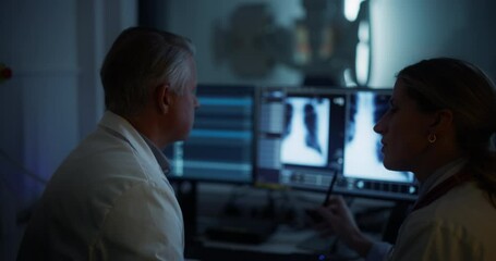 Aufkleber - Radiologists Analyze Chest X-rays in a Medical Monitoring Room, Examining Digital Scans on a Computer Screen. Male Specialist Having a Conversation with a Female Colleague, Focusing on Scans