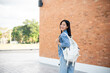 © bongkarn - A charming Asian female student going to her classroom, walking in her university outdoors area.