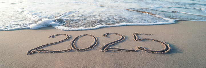 Wall Mural - photo of a beach with 2025 text written on the sand