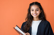 © PRASANNAPIX - indian school girl in black suit holding notebook